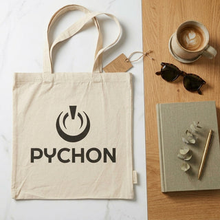 Bolsa PYCHON junto a un café y una libreta